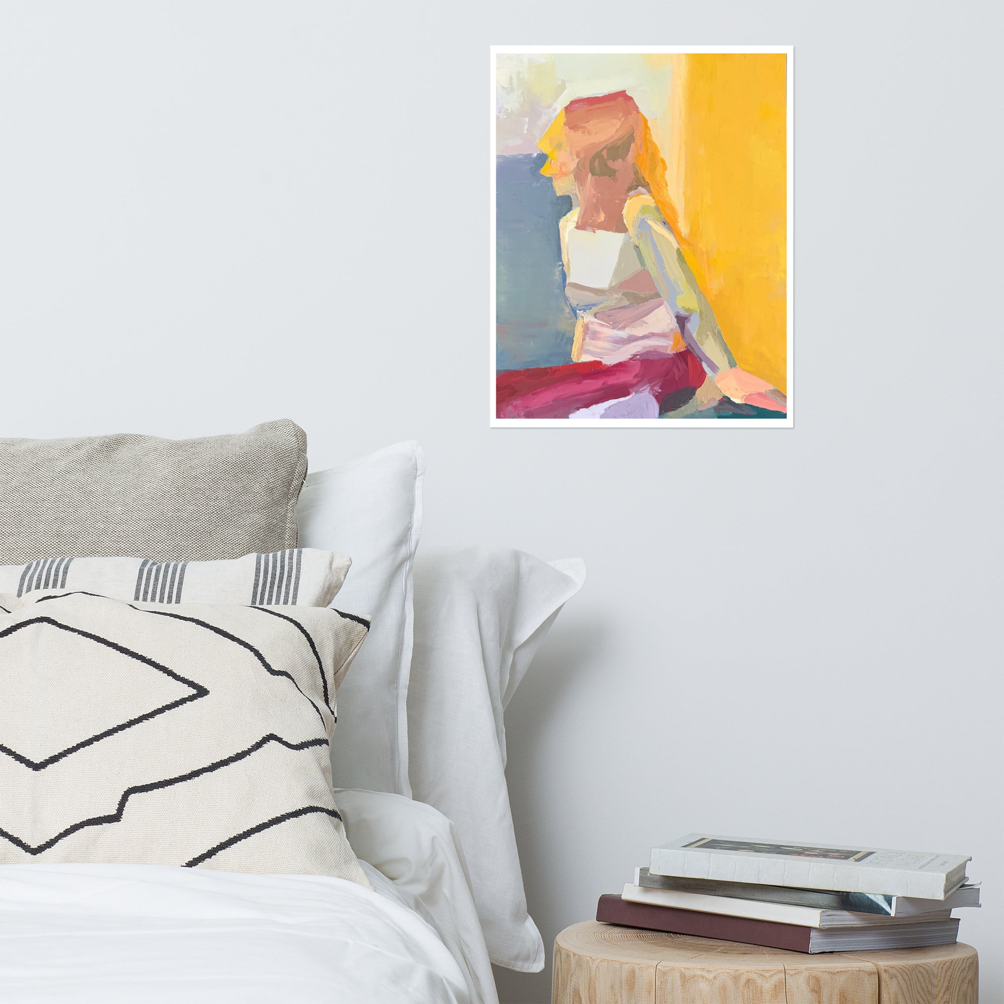 Mock up of a print of a painting on a bedroom wall. The painting is of a seated blond woman against a bright yellow background.