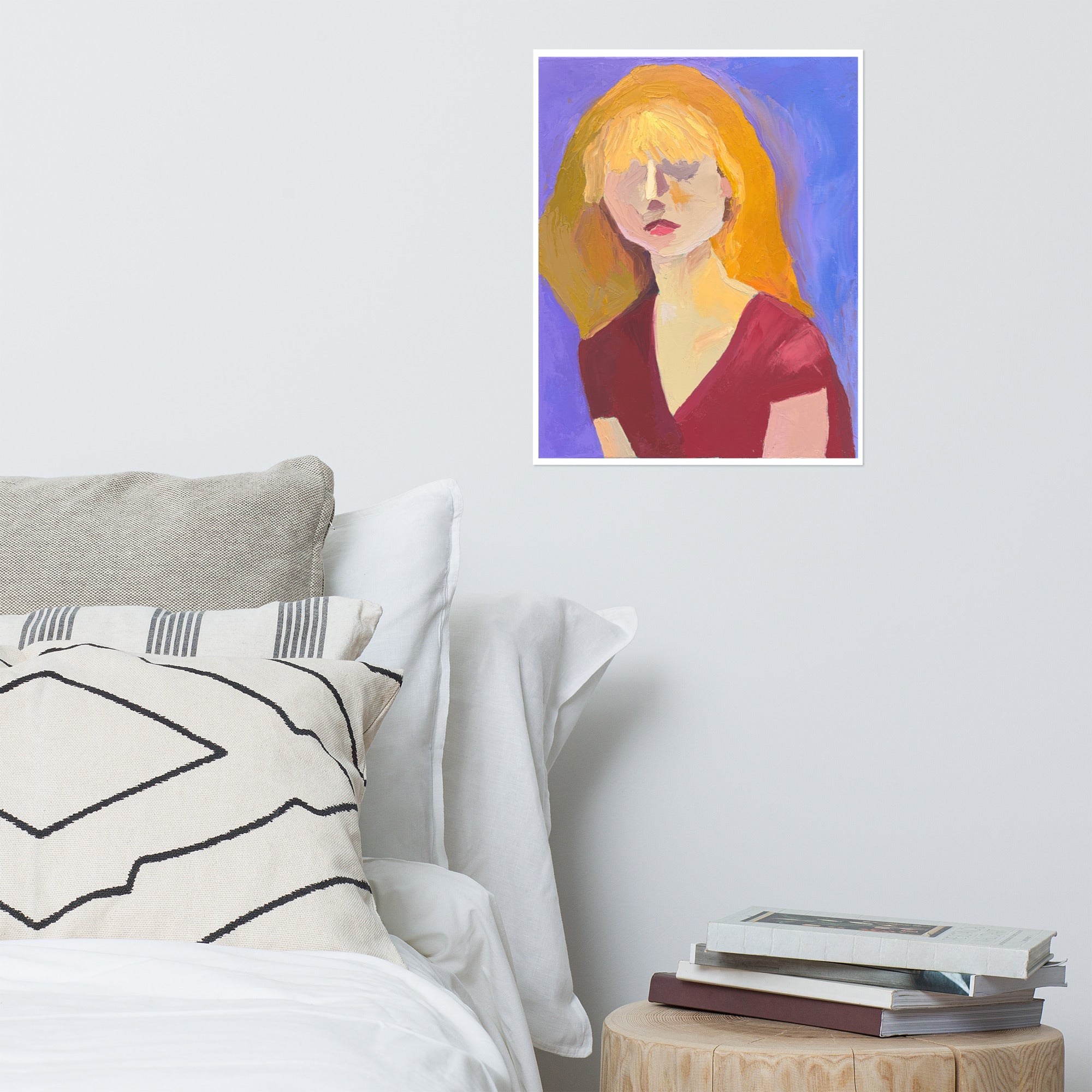 Mock up of a print of a painting on a bedroom wall. The painting is of a person with blond hair and red top.